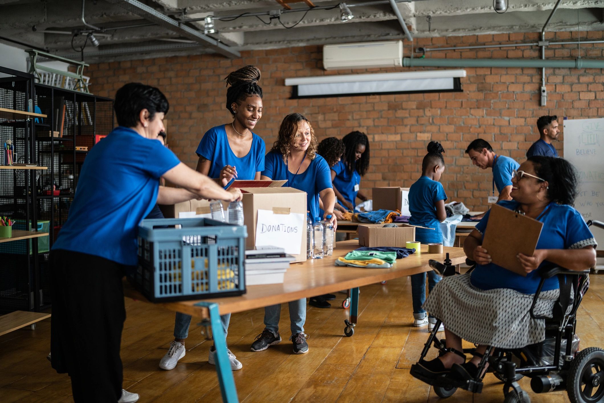 Volunteers arranging donations in a community center - including a disabled person