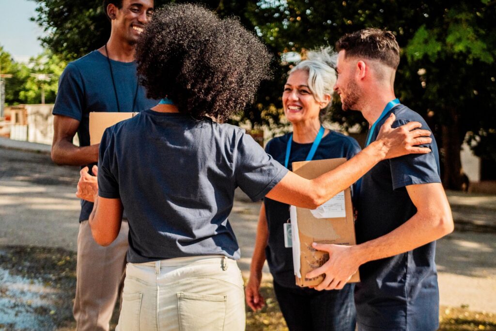 Volunteers talking and holding donation boxes outdoors